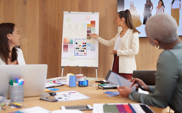 Team discussing fashion designs and color swatches.